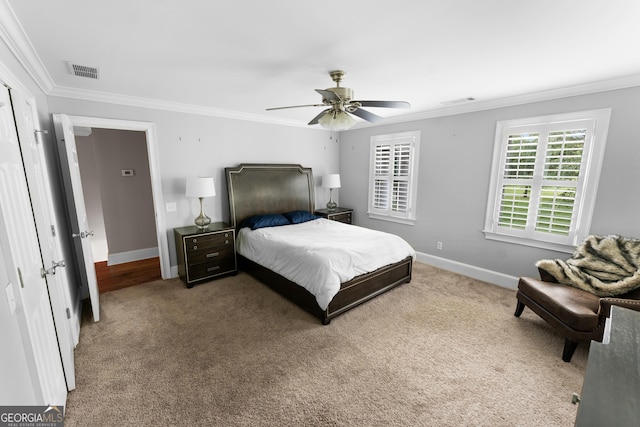 bedroom with carpet flooring, ceiling fan, and crown molding