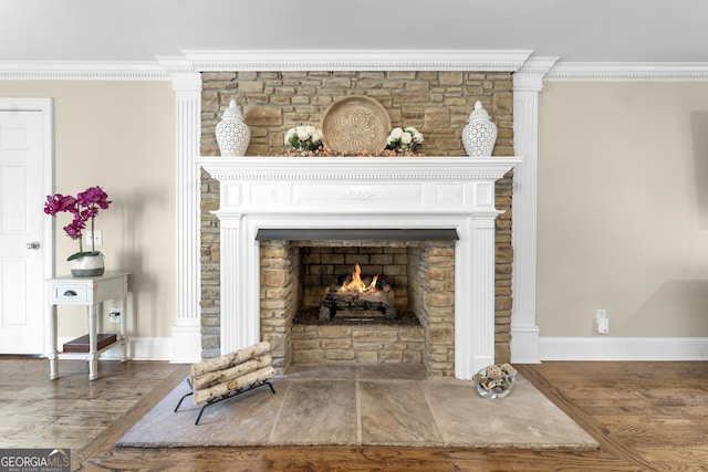 interior details with hardwood / wood-style flooring, crown molding, and a stone fireplace