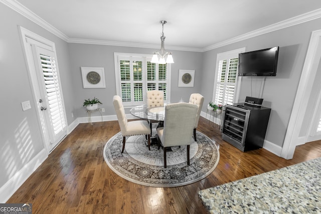 dining space with dark hardwood / wood-style flooring, an inviting chandelier, ornamental molding, and a wealth of natural light