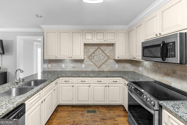 kitchen featuring sink, white cabinetry, ornamental molding, backsplash, and appliances with stainless steel finishes