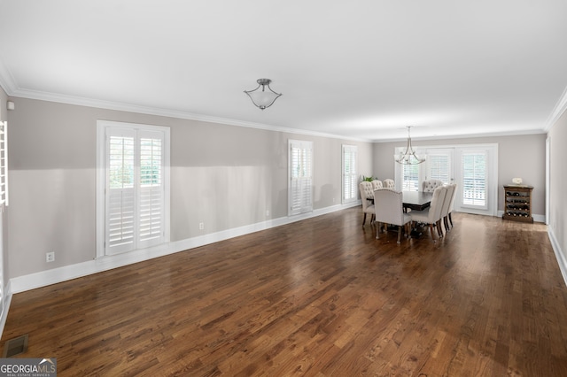 dining area featuring dark wood-type flooring, crown molding, and a chandelier