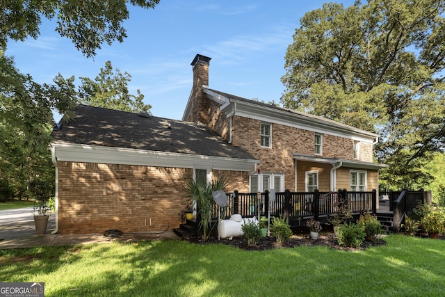 rear view of house with a yard and a wooden deck