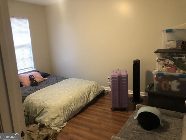 bedroom with dark wood-type flooring