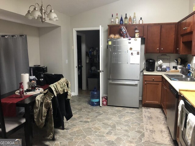 kitchen with sink, an inviting chandelier, lofted ceiling, and appliances with stainless steel finishes