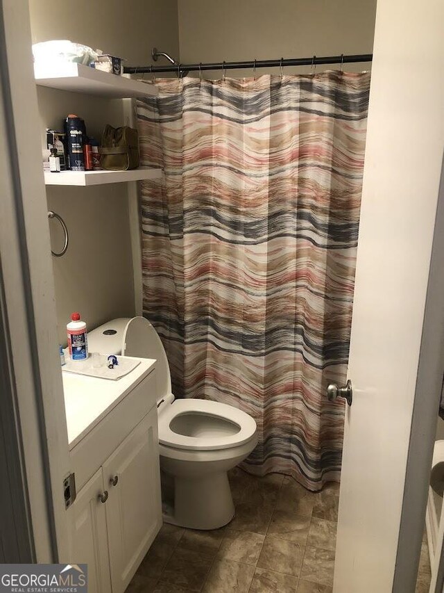 bathroom with a shower with shower curtain, vanity, and toilet