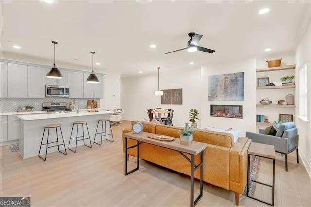 living room featuring ceiling fan and light hardwood / wood-style floors