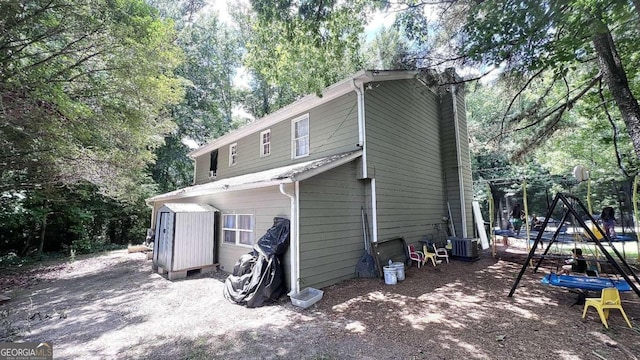 rear view of property with central AC and a trampoline