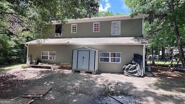 back of house featuring a shed