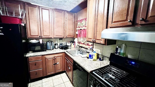 kitchen with sink, a textured ceiling, light tile patterned flooring, light stone countertops, and black appliances