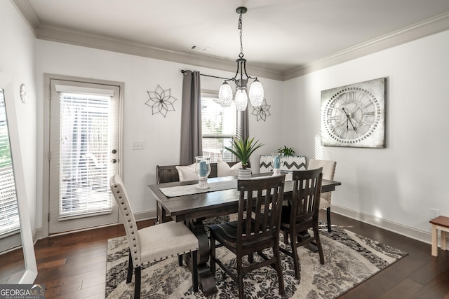 dining space featuring dark hardwood / wood-style flooring, an inviting chandelier, and crown molding