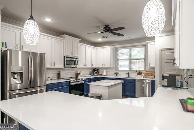 kitchen with a center island, decorative light fixtures, blue cabinets, white cabinets, and appliances with stainless steel finishes