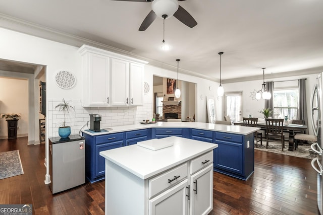 kitchen with white cabinetry, blue cabinets, backsplash, and a kitchen island