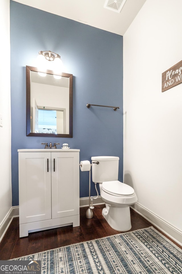 bathroom featuring toilet, wood-type flooring, and vanity