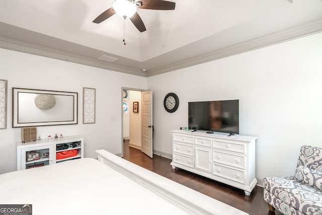 bedroom featuring dark wood-type flooring, ceiling fan, crown molding, and a tray ceiling