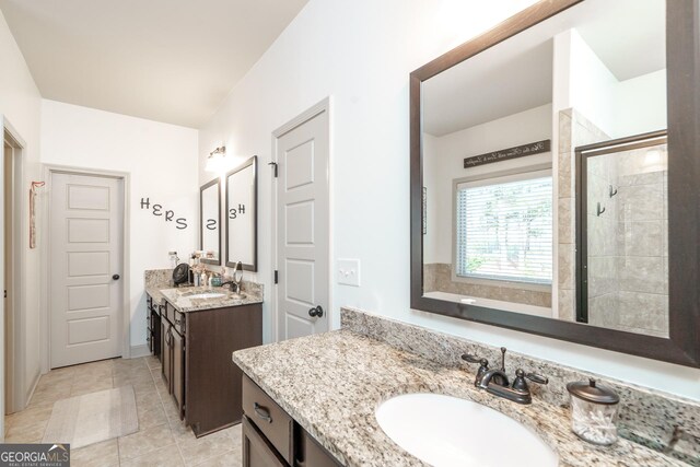 bathroom featuring a shower with door, vanity, and tile patterned floors