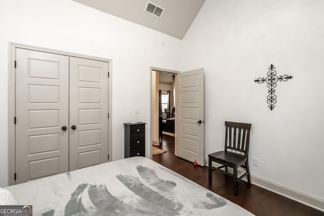 bedroom with high vaulted ceiling, a closet, and dark hardwood / wood-style floors