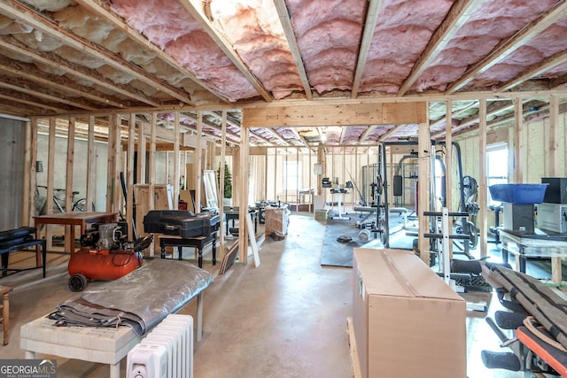 basement with a healthy amount of sunlight and radiator heating unit