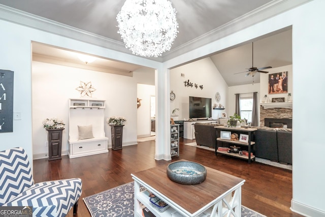 living room with a fireplace, lofted ceiling, ceiling fan with notable chandelier, dark hardwood / wood-style flooring, and crown molding