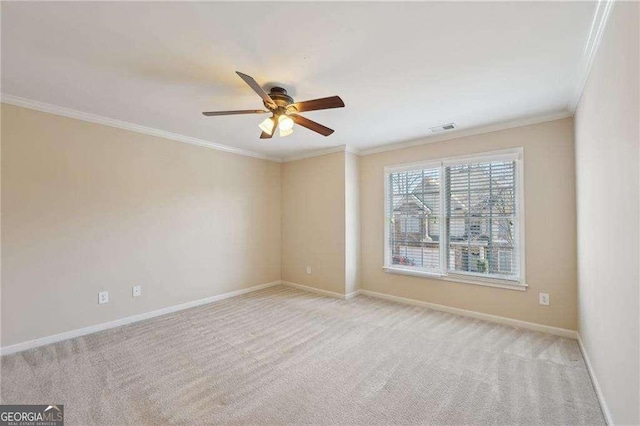 carpeted spare room with ceiling fan and crown molding