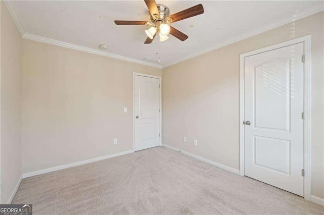 carpeted spare room featuring ceiling fan and crown molding