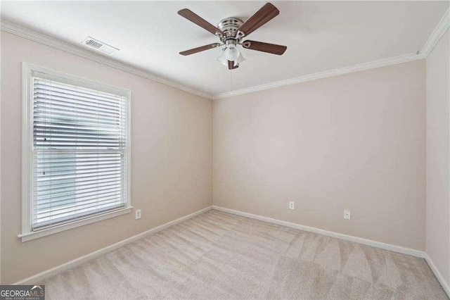 empty room with ceiling fan, crown molding, and light carpet