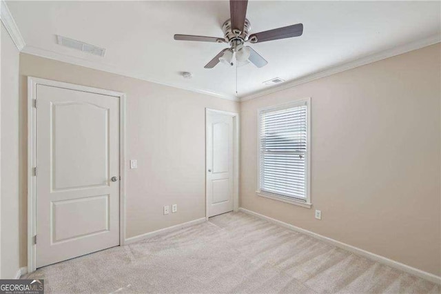 unfurnished bedroom featuring ceiling fan, light colored carpet, and ornamental molding