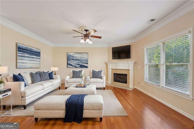 living room with ceiling fan, light hardwood / wood-style floors, and crown molding