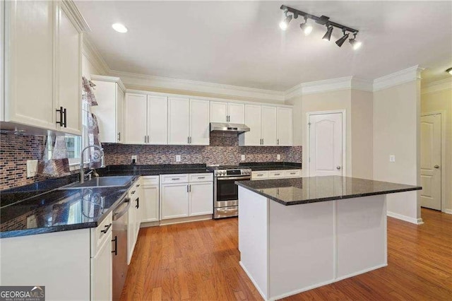 kitchen featuring sink, a kitchen island, white cabinets, and appliances with stainless steel finishes