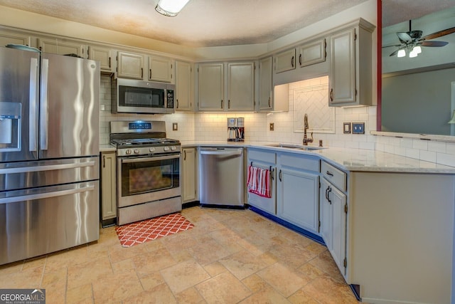 kitchen with stainless steel appliances, ceiling fan, light stone counters, decorative backsplash, and sink