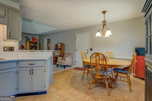 dining space featuring a textured ceiling, a chandelier, and a tray ceiling