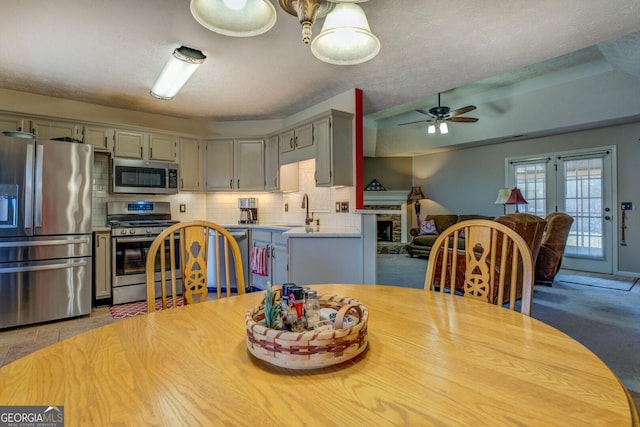 dining space featuring sink, ceiling fan, and a textured ceiling