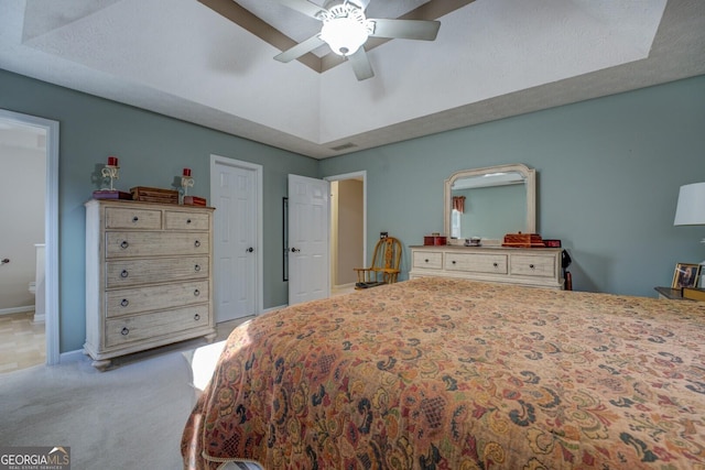 carpeted bedroom with ensuite bathroom, a textured ceiling, and ceiling fan