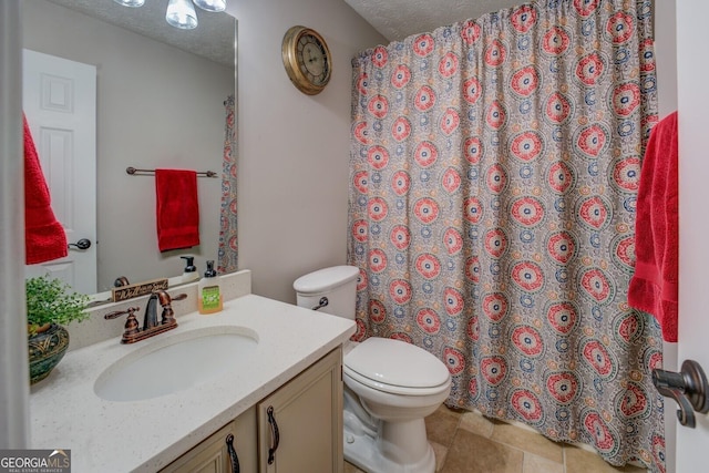 bathroom with toilet, a textured ceiling, and vanity