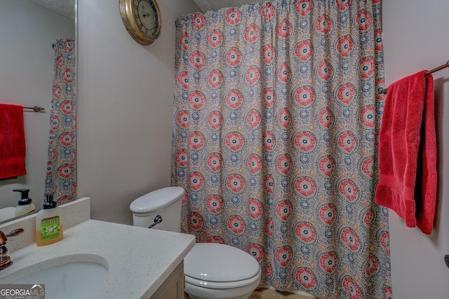 bathroom featuring toilet, vanity, and a textured ceiling