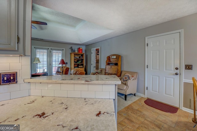 kitchen with kitchen peninsula, a textured ceiling, french doors, and ceiling fan