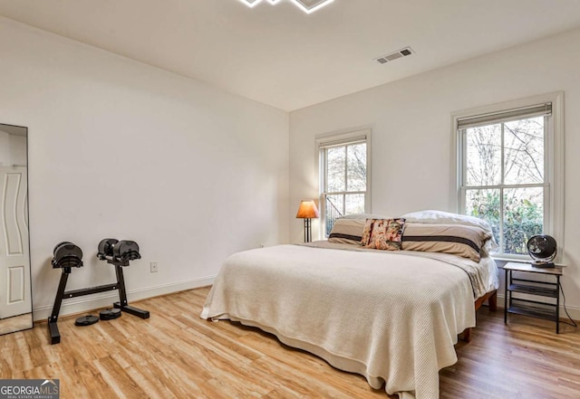 bedroom featuring wood-type flooring and multiple windows