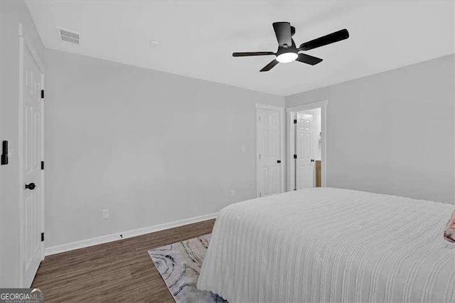 bedroom with ceiling fan and dark wood-type flooring