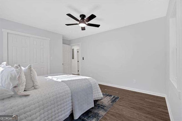 bedroom with a closet, ceiling fan, and dark hardwood / wood-style floors