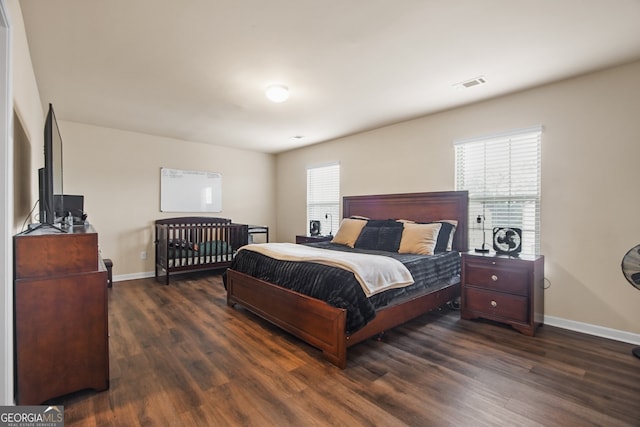 bedroom with dark hardwood / wood-style floors