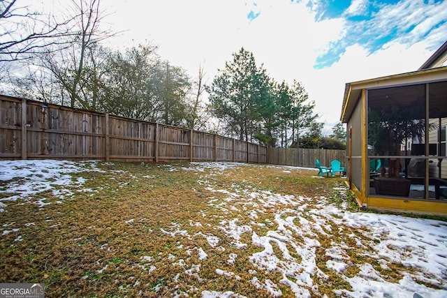 snowy yard featuring a sunroom