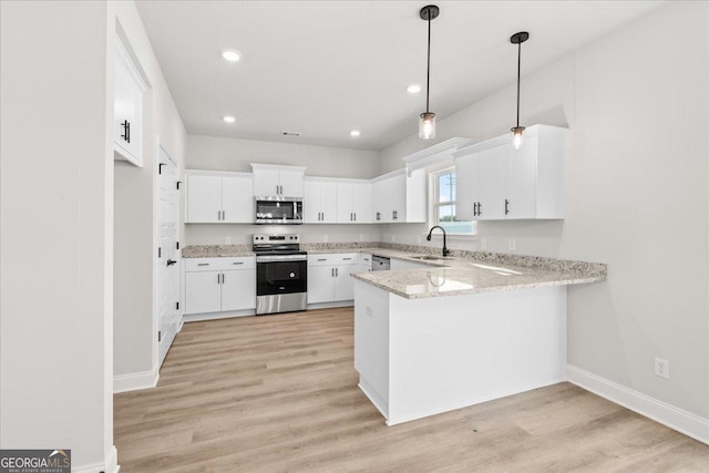 kitchen with stainless steel appliances, sink, hanging light fixtures, and white cabinets