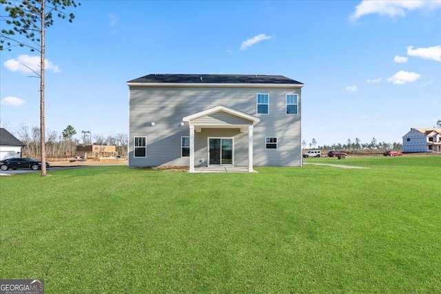 back of property with a yard and a patio