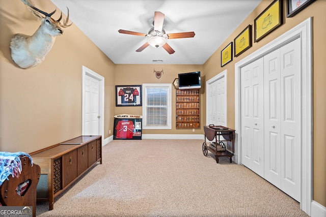 interior space with light colored carpet and ceiling fan