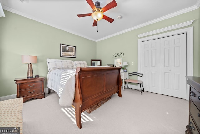 carpeted bedroom featuring ornamental molding, ceiling fan, and a closet