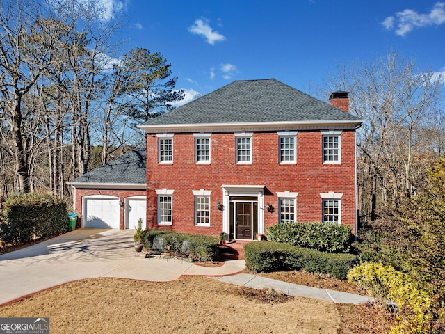 colonial house featuring a front yard and a garage