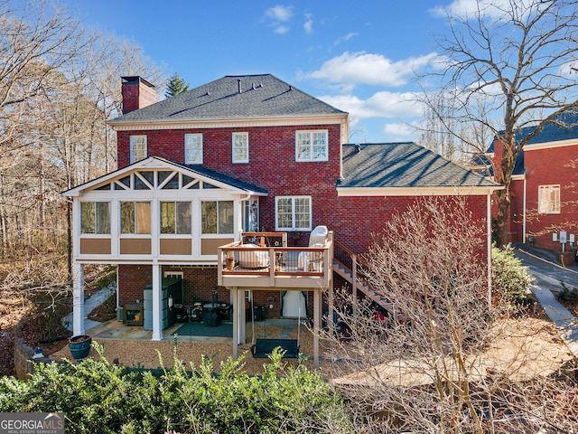 back of house featuring a patio area, a deck, and a sunroom