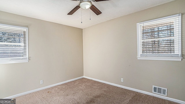 carpeted spare room with ceiling fan and a textured ceiling