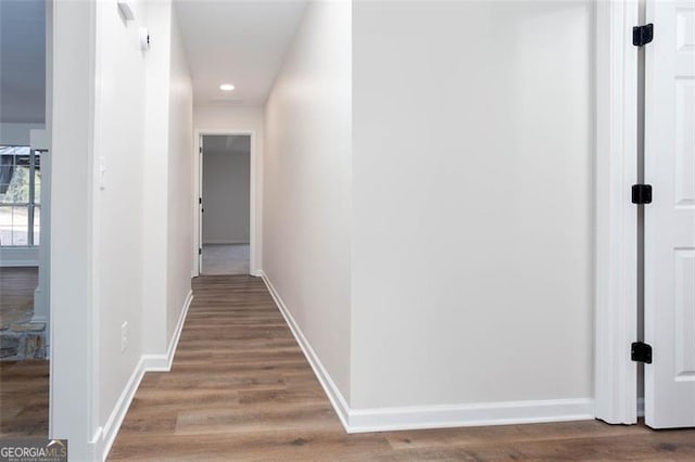 corridor with hardwood / wood-style flooring