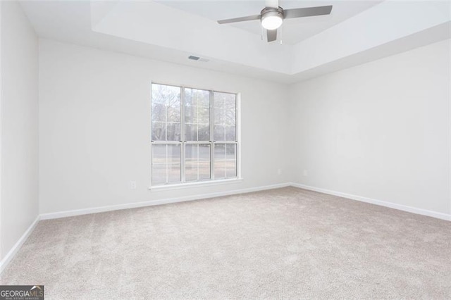 unfurnished room featuring carpet flooring, ceiling fan, and a tray ceiling