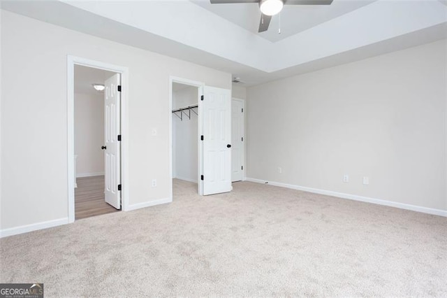 4100 Chanticleer Dr, Kennesaw, GA 30152 - unfurnished bedroom with carpet floors, baseboards, a walk in closet, ceiling fan, and a tray ceiling